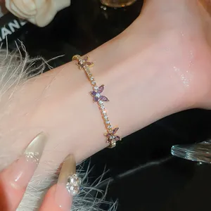Bracelet doré élégant avec des fleurs en zircon violettes au poignet, style luxueux