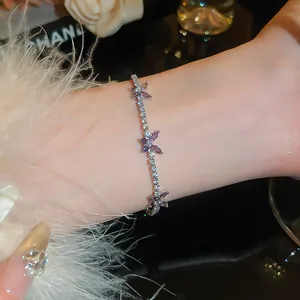Vue détaillée d'un bracelet argenté avec des charmes papillon violets et zircons