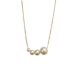 Elegant necklace with four graduating white pearls on a minimalist gold box chain