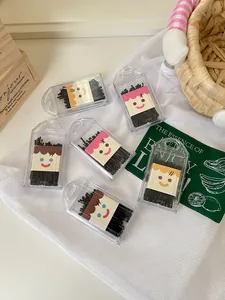 Detailed view of black bobby pins in cute cartoon face storage boxes