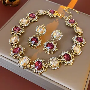 Close-up of vintage court style jewelry set with purple and champagne crystals in gold.