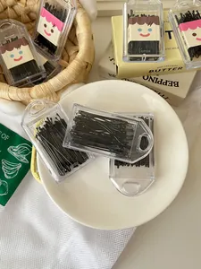 Close-up of basic black bobby pins in clear plastic cases with cute smiling face designs