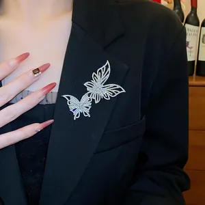 Dettaglio di una spilla a farfalla con strass scintillanti su un blazer nero elegante