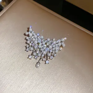 Dettaglio di una spilla a farfalla scintillante decorata con strass e perle bianche