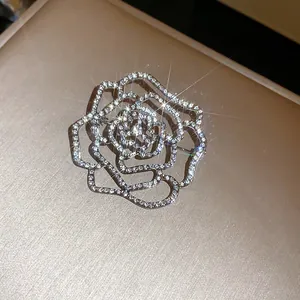 Macro di una scintillante spilla a rosa traforata con brillanti cristalli micro-pave