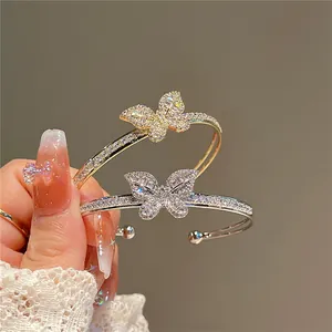Close-up of sparkling zircon butterfly bracelets in gold and silver plating.