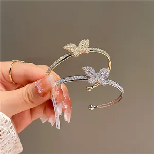 Close-up detail of gold and silver butterfly bracelets with shimmering zirconia stones