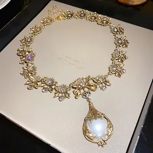 Vintage palace style gold necklace featuring a large pearl pendant and crystal accents