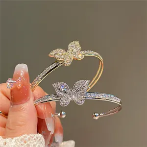 Close-up of sparkling butterfly open bangles with zircon inlay in gold and silver