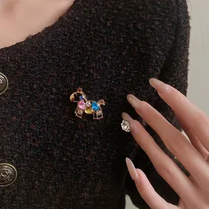 Vintage golden horse brooch with colorful rhinestones on a tweed jacket
