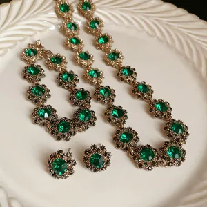 Vista macro dettagliata della collana e degli orecchini vintage a fiori verde smeraldo