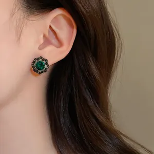 Primo piano dettagliato di un orecchino a lobo vintage con cristallo verde smeraldo
