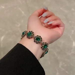 Elegante bracciale stile corte vintage con cristalli floreali verdi indossato al polso.