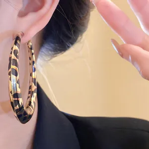 Primer plano de pendientes de aro retro con estampado de leopardo detallado