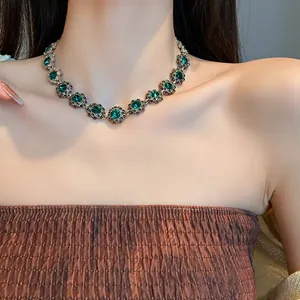 Dettaglio macro di una collana girocollo con fiori di strass verde smeraldo