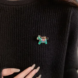 Detailed macro shot of a vintage style enamel horse brooch pinned on a black knit sweater