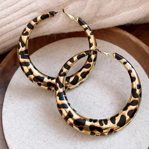 Vista detallada de pendientes de aro dorados retro con estampado de leopardo
