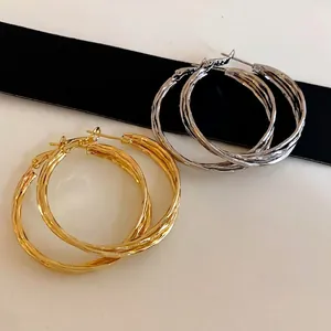 Elegant gold and silver twisted geometric hoop earrings for a minimalist fashion look
