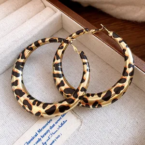 Vista detallada de pendientes de aro grandes con estampado leopardo en un joyero