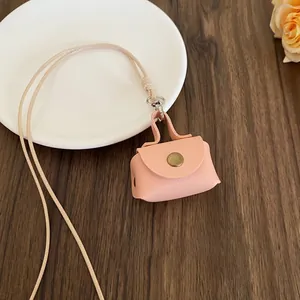 Macro view of a cute mini pink faux leather pouch necklace with a gold button closure