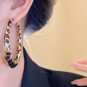 Primer plano de pendientes de aro con estampado de leopardo en estilo retro