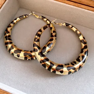 Detalle macro de pendientes de aro retro con estampado de leopardo y acabado dorado