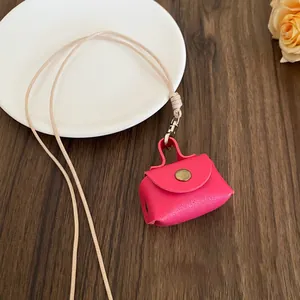 Detailed view of the vibrant pink mini bag pouch attached to a beige neck lanyard