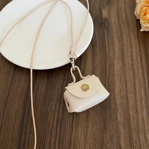 Close-up of mini cream leather coin purse necklace with vintage bronze button