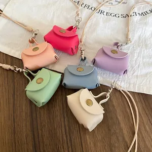 Group of colorful mini leather coin purse necklaces in various sweet pastel shades on wood table