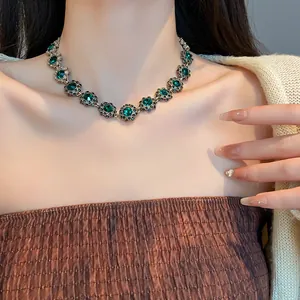 Elegante collana girocollo vintage con fiori di strass smeraldo sul collo di una modella