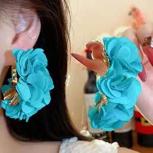 Detailed view of elegant cyan chiffon flower C-shape earrings with gold leaf charms.