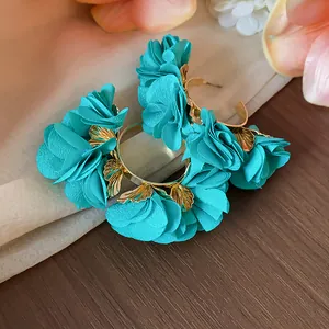 Detailed view of elegant teal chiffon flower C-shape hoop earrings with gold leaf accents.
