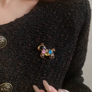 Close-up of a luxury vintage horse brooch with colorful rhinestones on tweed jacket