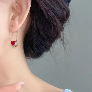 Close-up view of a sweet colorful resin bead hoop earring worn on a model ear for summer
