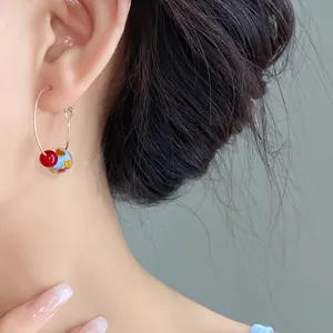 Close-up of summer colorful resin hoop earrings worn on ear for a sweet temperament look