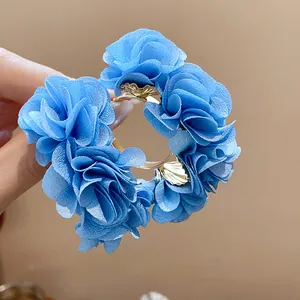 Detail view of elegant blue chiffon fabric flower C-shaped earrings for beach vacation