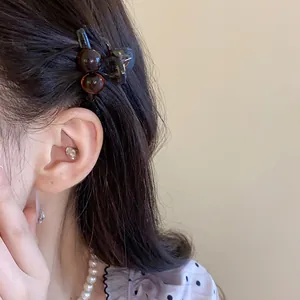Close-up of a retro amber acrylic mini hair claw clip worn on side hair