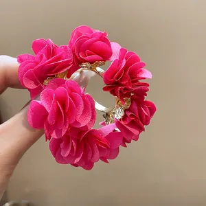 Macro detail of elegant fuchsia chiffon flower C-shaped earrings with pearl accents