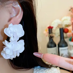 Elegant white chiffon flower C-shaped drop earrings shown as a close-up detail on model
