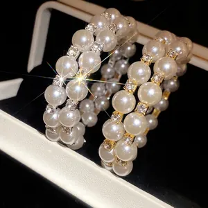 Elegant double-layer open bangle featuring lustrous pearls and sparkling rhinestones.