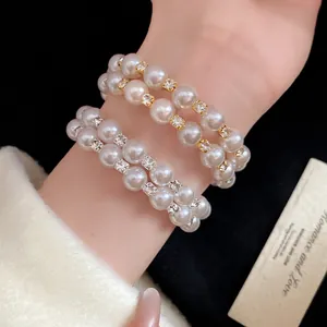 Close-up of elegant double-layered pearl bracelets with sparkling rhinestones on wrist