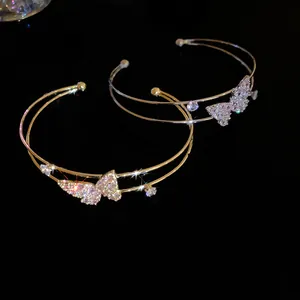 Close-up of sparkling zirconia butterfly on double-layered gold and silver bracelets
