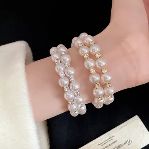 Elegant close-up view of double-layered pearl bracelet featuring shimmering rhinestones on wrist