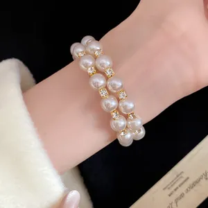 Detailed view of an elegant double-layered pearl bracelet featuring gold rhinestone spacers