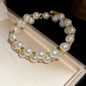 Close-up of double-layer pearl bracelet with rhinestone-encrusted gold spacers