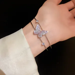 Detail of elegant double-layer open bracelet with sparkling zircon butterfly motif.