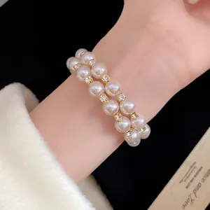 Close-up of elegant double-layer pearl bracelet with sparkling rhinestone accents on wrist