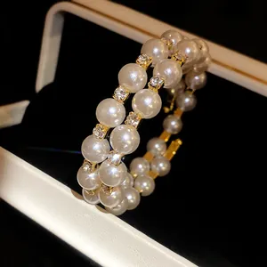 Close-up of double-layer pearl bracelet with rhinestone accents and gold finish