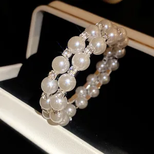 Detail shot of an elegant double-layer pearl bracelet featuring sparkling square rhinestones