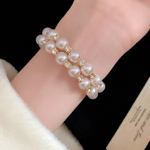 Close-up of double-layer pearl bracelet with sparkling rhinestone accents on wrist.